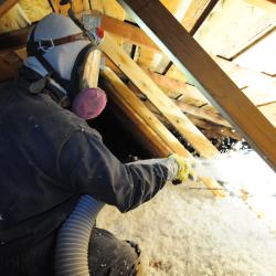 Technician from Eastside spraying insulation in an attic.