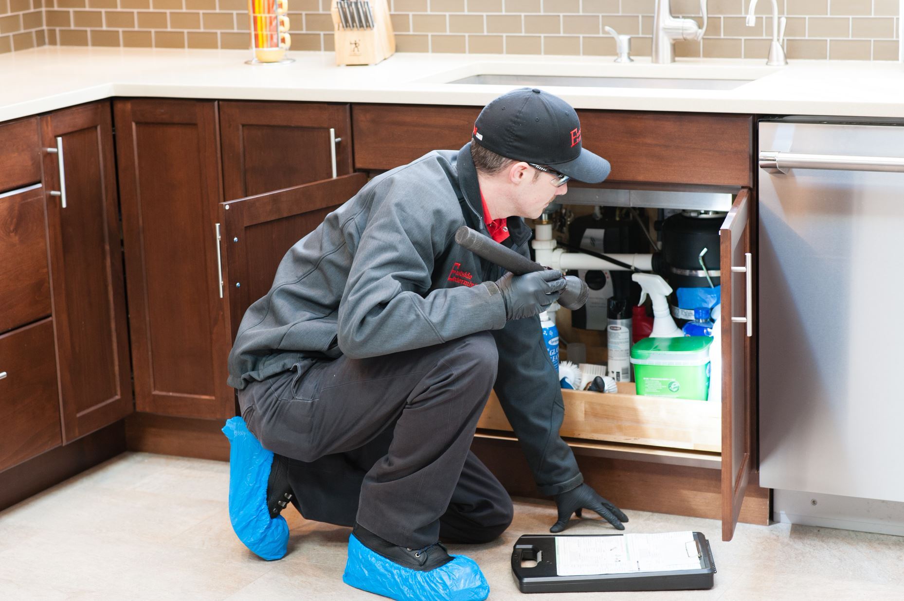 Man inspecting underneath sink