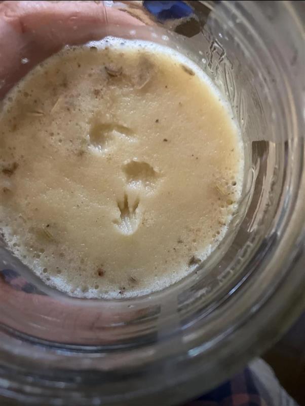 Image of a cup with grease in it, with a small footprint